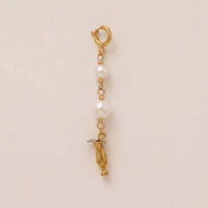 Detailed view of stainless steel charm with white pearls and a golden cocktail glass pendant