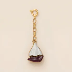 Detailed view of a gold surfboard pendant with white and purple enamel for beach accessories.