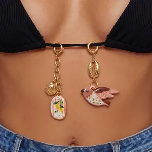 Primo piano dettagliato di ciondoli decorativi con uccelli e limoni su un bikini