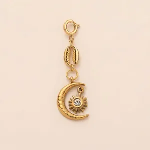 Vue détaillée d'un pendentif céleste doré avec éléments lune, soleil et coquillage