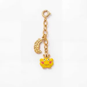 Detailansicht der 18K vergoldeten Edelstahlkette mit gelbem Frosch und Federanhängern.