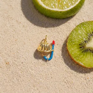 Detailansicht eines süßen Goldpudding- und blauen Schnorchelanhängers auf Sand