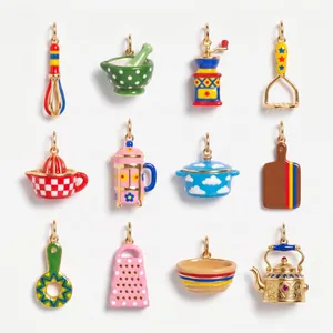 Detailed view of 12 colorful enamel miniature kitchenware charms in a grid.