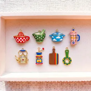 Detailed view of colorful enamel kitchenware charms including teapots and coffee grinders