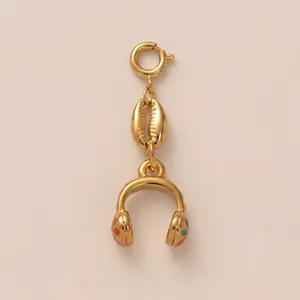 Close-up detail of a gold headphone pendant featuring a shell charm and colorful dots