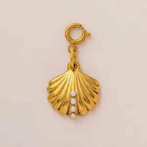 Detail of a vintage-style gold shell pendant with pearl accents for necklaces.