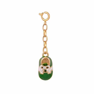 Dettaglio del ciondolo a scarpa da calcio verde con catena dorata e strass scintillante