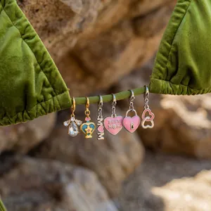 Close-up detail of colorful DIY stainless steel pendants hanging on a green bikini strap