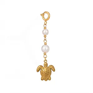 Detailed macro view of an 18K gold plated sea turtle jewelry pendant featuring white pearls
