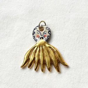 Detailed view of a gold-plated stainless steel and ceramic artistic pendant with intricate patterns