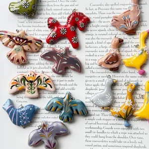Close-up of Nordic folk art animal pendants with floral patterns on vintage book