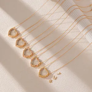 Detailed view of colorful heart-shaped crystal necklaces with clear glass center and gold chain.