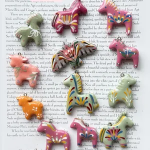 High-detail macro view of colorful folk art style animal pendants on open book background