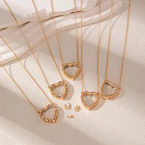 Detailed view of gold-plated heart-shaped necklaces with transparent glass and colorful gems.