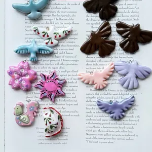 Collection of colorful bird-shaped stainless steel pendants with floral patterns