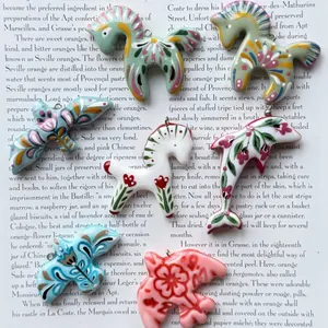 Close-up of colorful folk art animal pendants featuring floral patterns for DIY jewelry