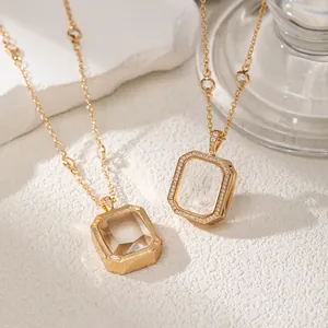 Close-up detail of gold rectangular glass locket necklace with sparkling pave border