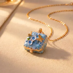Detailopname van een elegant blauw emaille medaillon met bloemen en gouden vlinders