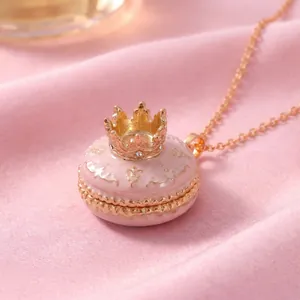 Detailaufnahme der rosa Macaron-Halskette mit goldener Krone und Medaillon-Detail