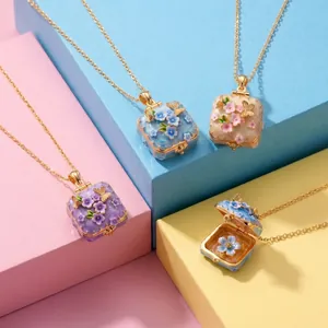Detailweergave van geëmailleerde vierkante locket-kettingen met bloem- en vlinderpatronen