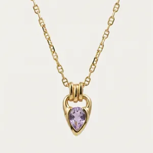 Close-up of purple teardrop zircon pendant on a gold plated horseshoe bail