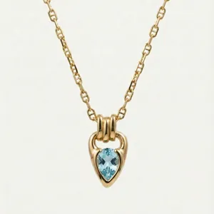 Detailed view of an 18K gold plated necklace with a pear-cut blue zirconia pendant