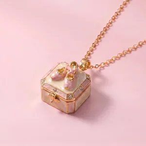 Close-up of a fairy tale style openable locket necklace with pink ballet shoes