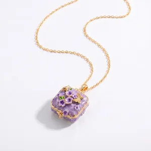 Detailweergave van paarse emaille locket in sprookjesstijl met bloem- en vlinderaccenten