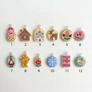 Collection of twelve Russian folk art style charms featuring dolls, houses and flowers