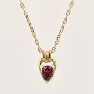 Detailed macro view of 18K gold-plated necklace featuring teardrop red zircon pendant