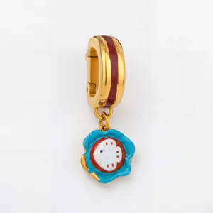 Detailed view of gold-toned marine life charm pendant featuring blue and red enamel work