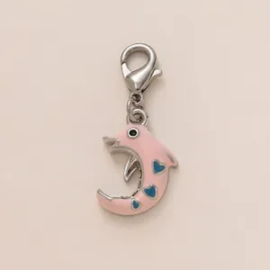 Nahaufnahme eines rosa Delfin-Anhängers mit blauen Herzen und silbernem Karabiner