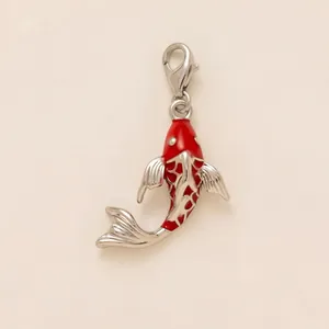 Detailansicht eines silbernen Fisch-Anhängers mit rotem Emaille und Karabiner.