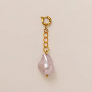 Dettaglio di un ciondolo con perla barocca rosa e catena in acciaio inossidabile placcata oro 18K
