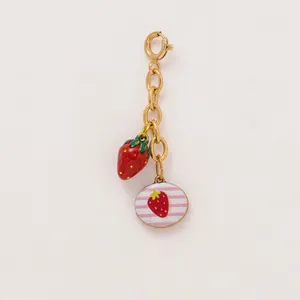 Detailed view of gold chain charm featuring 3D strawberry and striped enamel pendant.