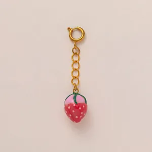 Close-up of a red strawberry charm with a gold-tone chain and spring ring clasp