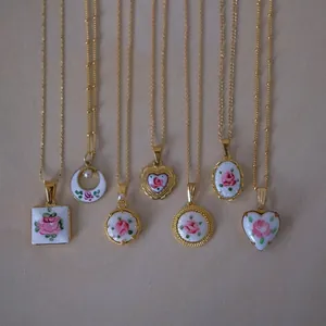 Parure de colliers dorés vintage avec divers pendentifs roses en émail rose