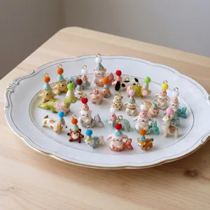 Bunte handbemalte Tieranhänger mit Partyhüten für die DIY-Schmuckherstellung.