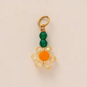 Accessorio ciondolo a fiore con perline e cristalli verdi e gialli per moda mare e bikini.