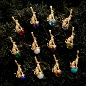 Variety of vintage Egyptian Bastet cat pendants with colorful gemstones and gold plating
