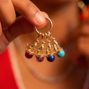 Detailed close-up of vintage gold-plated Bastet cat pendants with various colorful gemstones