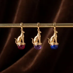 Detailed view of Egyptian Bastet cat pendants with colorful natural gemstone bases.