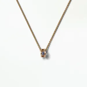 Detailed shot of elegant rose gold hollow pendant set with purple gemstone on fine chain