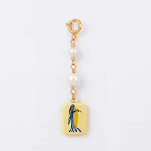 Dettaglio charm in perle con pendente a forma di pesce dipinto per catena da bikini
