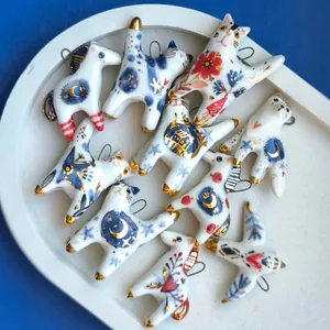 Collezione di vari ciondoli animali in ceramica con motivi floreali blu e dettagli d'oro