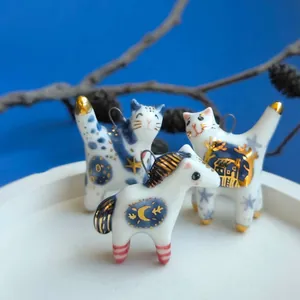 Vista dettagliata di ciondoli animali in ceramica blu e bianca con accenti dorati