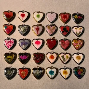 Collection of retro heart-shaped locket pendants with dried flowers in gold and silver frames
