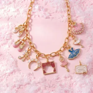Gros plan d'un collier à breloques rose sur le thème du ballet avec chaîne dorée.