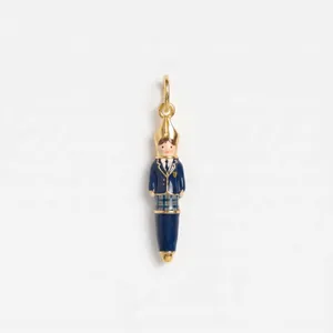 Detail view of a whimsical school girl stationery pendant with enamel finish and gold ring.
