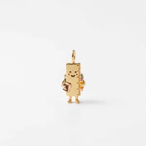 Detailed view of gold-plated cartoon ruler pendant with smiling face and stationery